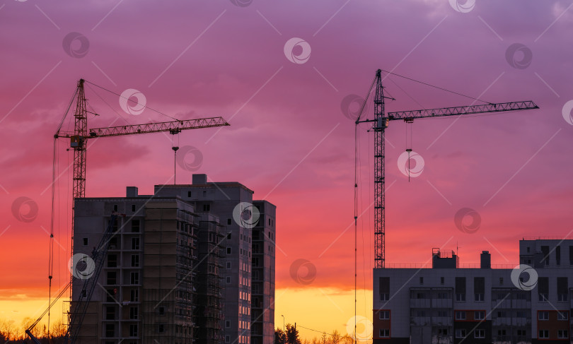 Скачать Краны и строящиеся здания на фоне оранжевого и r фотосток Ozero