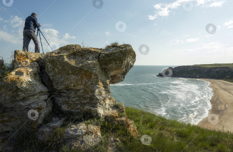 Скачать Взрослый мужчина с фотоаппаратом стоит на краю фотосток Ozero