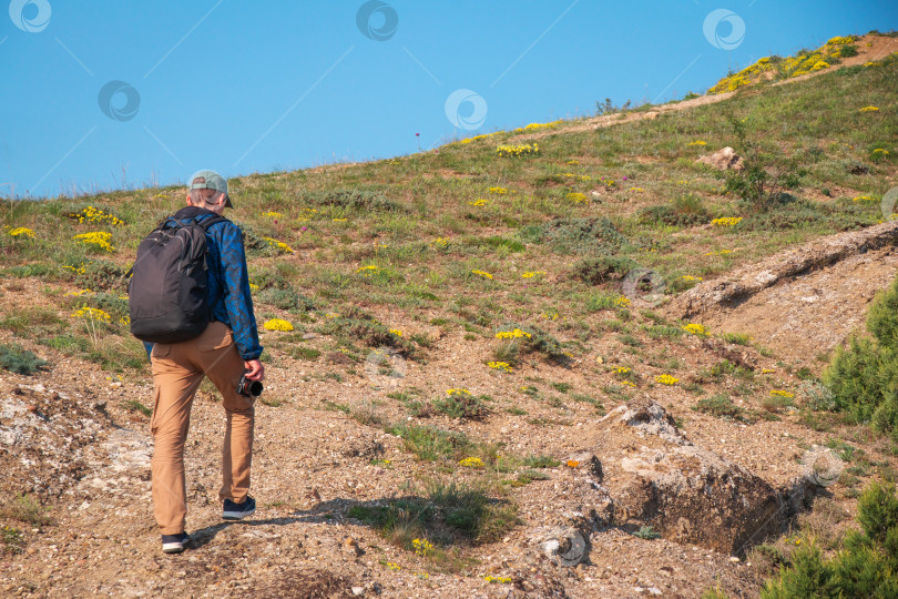 Скачать Путешественник-мужчина-турист с рюкзаком, смартфоном и фотоаппаратом в руках фотосток Ozero