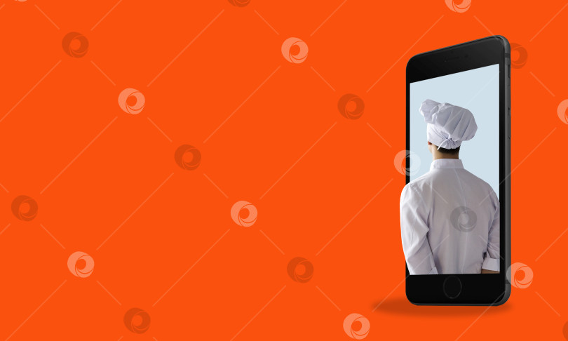 Скачать Концепция приготовления пищи и кулинарные приложения. Шеф-повар в телефоне на красном фоне с пробелом для текста. фотосток Ozero
