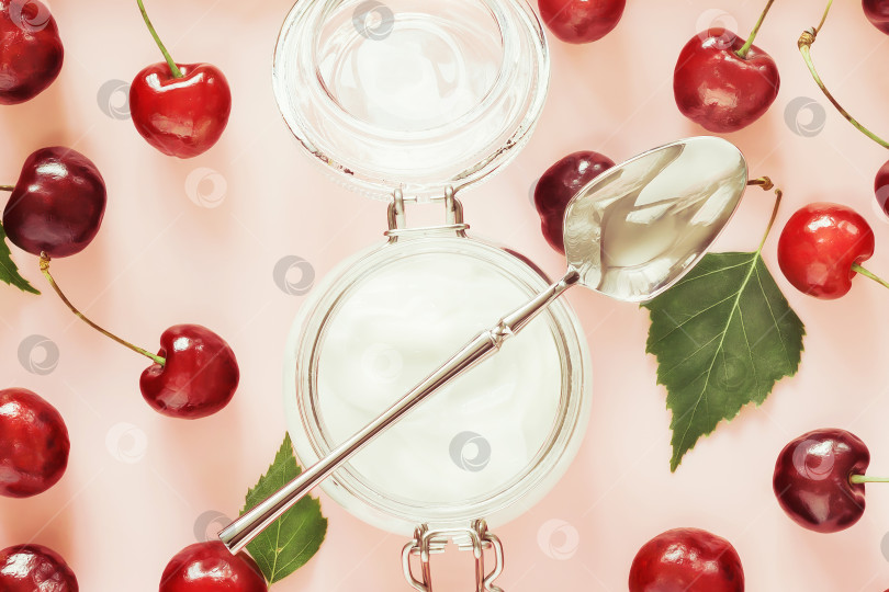 Скачать Органическая фермерская вишня и натуральный йогурт в стеклянной банке на розовом фоне фотосток Ozero