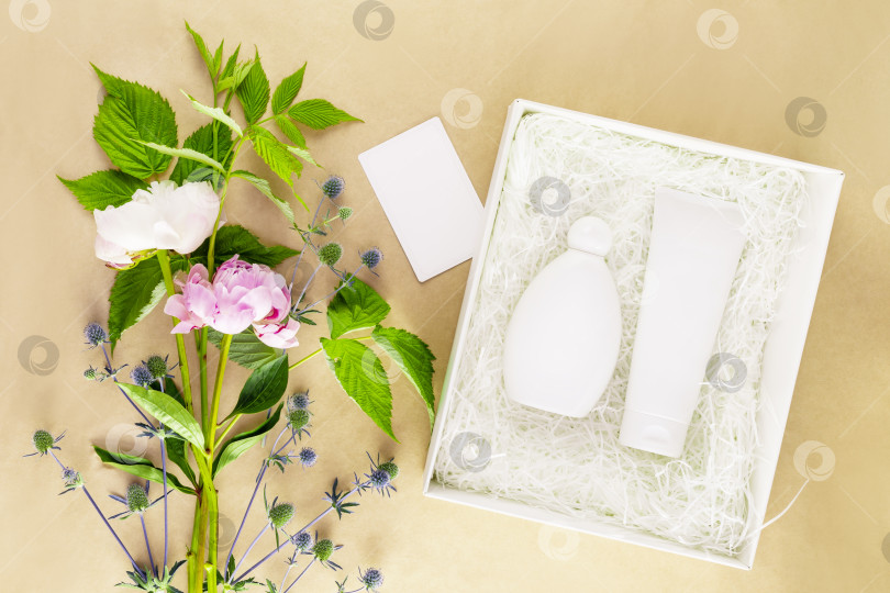 Скачать Подарочная белая коробка с косметическими средствами с пустой поздравительной открыткой и розовыми пионами фотосток Ozero