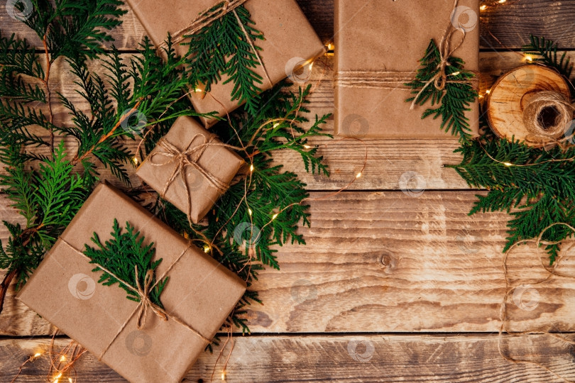 Скачать Коробки, упакованные в крафт-бумагу и натуральный шпагат на деревянном фоне.Экологически чистый материал.Рождество и Новый год. фотосток Ozero