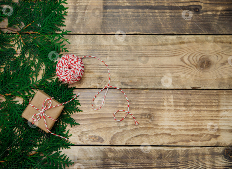Скачать Коробки, упакованные в крафт-бумагу, и зеленые ветки на деревянном фоне.Рождество и Новый год. фотосток Ozero