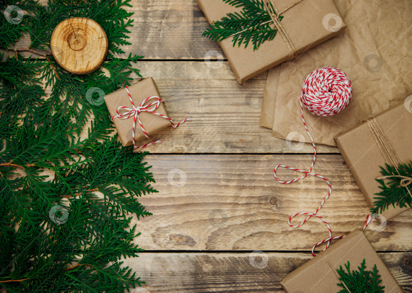 Скачать Коробки, упакованные в крафт-бумагу, ветки на деревянном фоне.Экологически чистый материал.Рождество и Новый год. фотосток Ozero