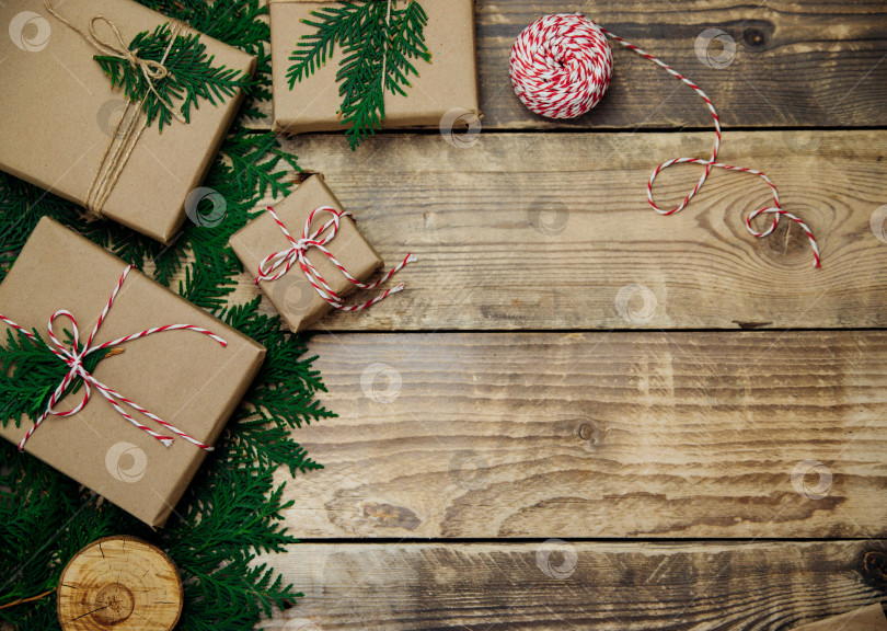 Скачать Коробки, упакованные в крафт-бумагу, ветки на деревянном фоне. Экологически чистый материал.Рождество и Новый год. фотосток Ozero