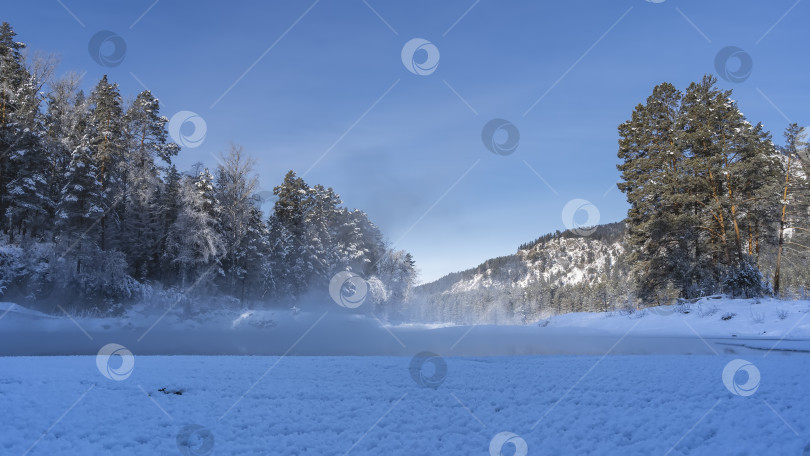 Скачать Пар поднимается над незамерзающей зимней рекой. фотосток Ozero