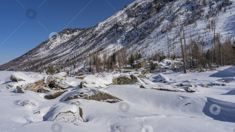 Скачать Слой чистого нетронутого снега покрывает живописные валуны. фотосток Ozero