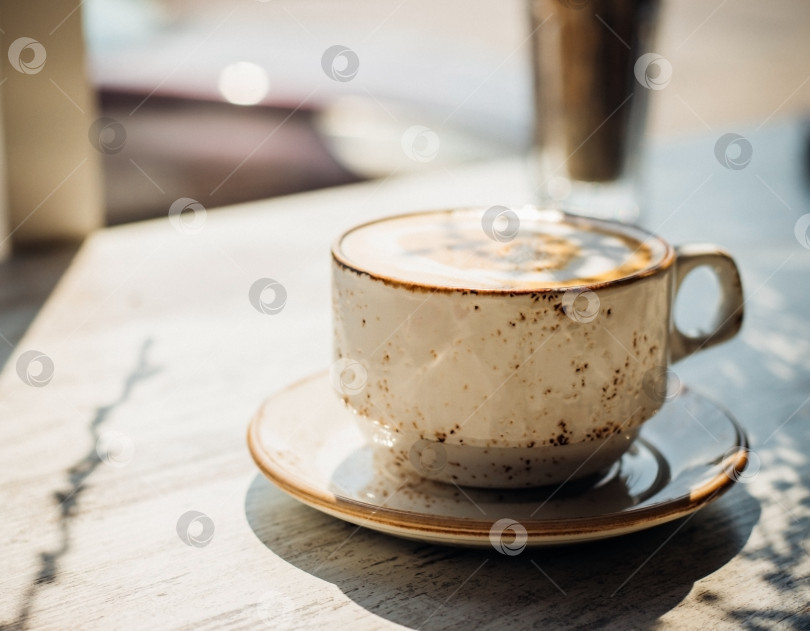 Скачать Капучино в красивой керамической чашке стоит на столе в кафе. Вкусный ароматный завтрак. фотосток Ozero