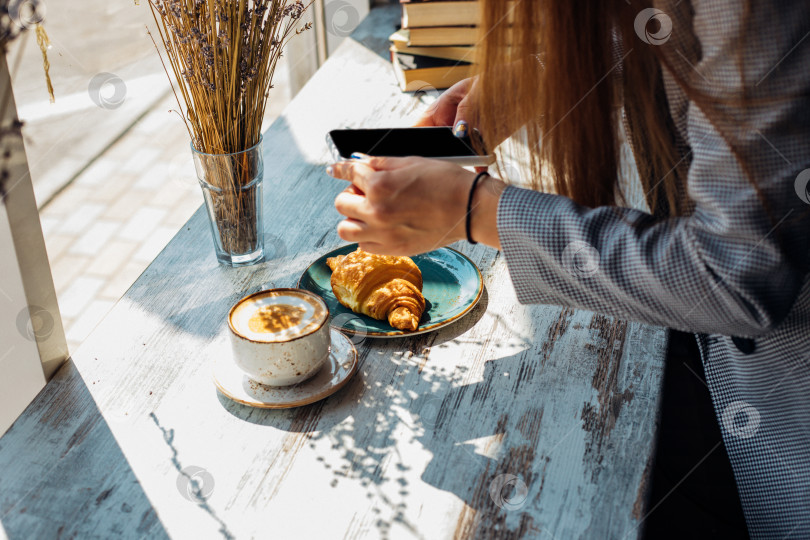 Скачать Концепция "Люди, досуг и технологии": молодая женщина фотографирует сладкий десерт на мобильный телефон. фотосток Ozero