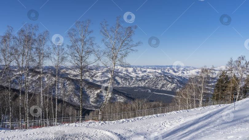 Скачать По краю заснеженного горнолыжного склона установлено ограждение. фотосток Ozero