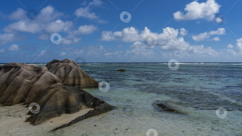 Скачать Живописные гранитные валуны на песчаном пляже тропического острова. фотосток Ozero