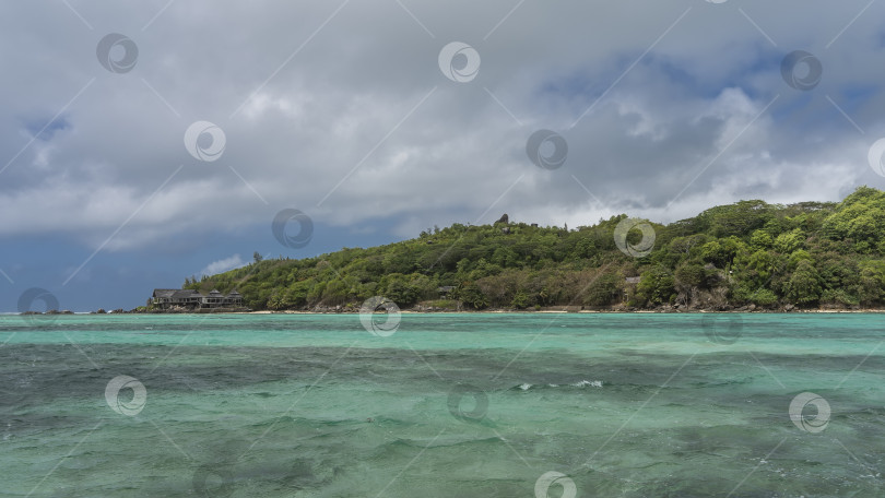 Скачать Остров в бирюзовом океане полностью зарос тропической растительностью. фотосток Ozero