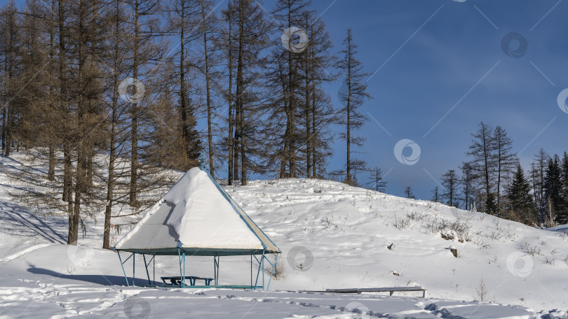 Скачать В долине есть беседка со слоем снега на пирамидальной крыше. фотосток Ozero