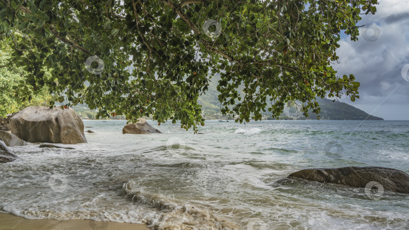 Скачать Волны бирюзового океана накатывают на берег и пенятся на песке. фотосток Ozero
