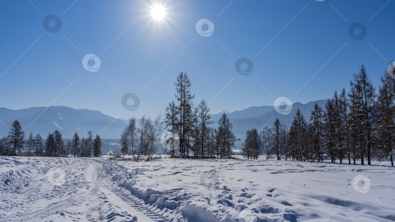 Скачать Дорога вытоптана в заснеженной долине. фотосток Ozero