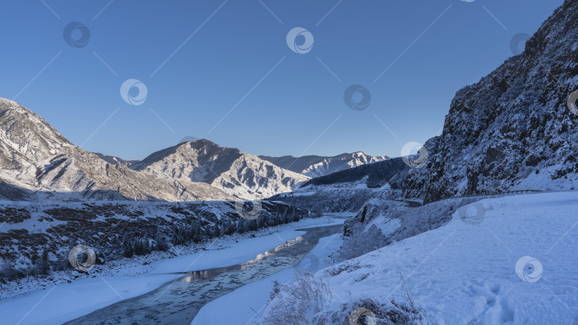 Скачать Незамерзающая река течет в заснеженной долине.= фотосток Ozero