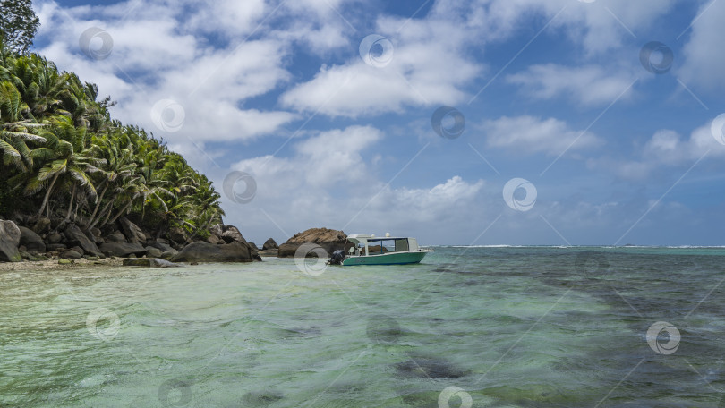 Скачать Лодка пришвартована у побережья тропического острова. фотосток Ozero