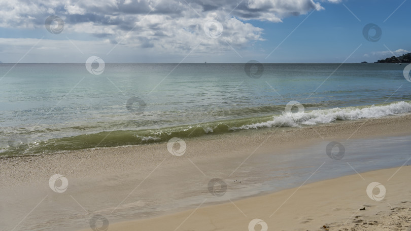 Скачать Волна бирюзового океана накатывает на берег, извиваясь и растекаясь по пляжу фотосток Ozero