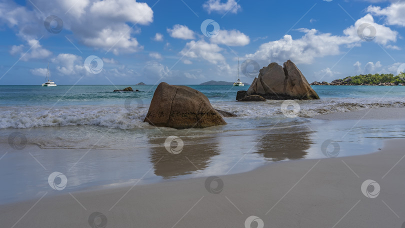 Скачать Живописные гранитные скалы в полосе прибоя на тропическом пляже. фотосток Ozero