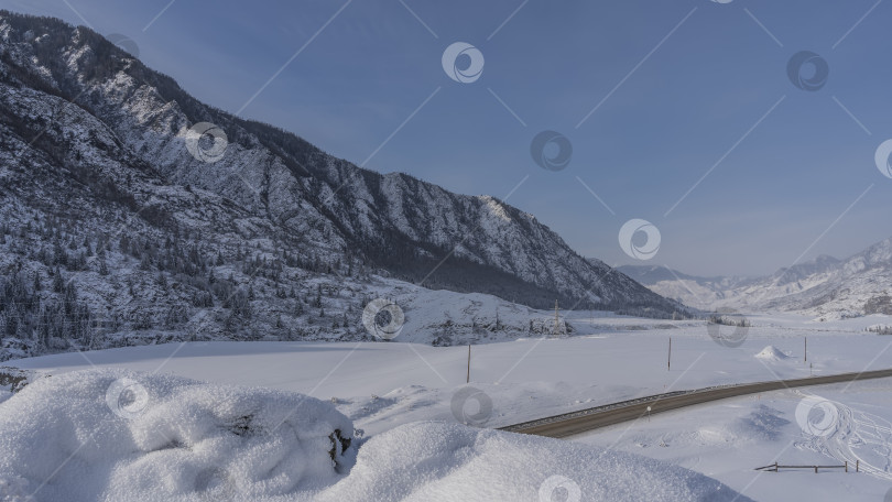 Скачать Шоссе проходит через заснеженную долину. фотосток Ozero