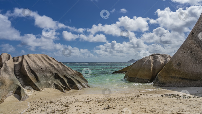 Скачать Живописные гранитные скалы с округлыми складчатыми склонами на пляже тропического острова. фотосток Ozero