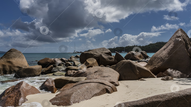 Скачать Живописные гранитные валуны разбросаны по пляжу тропического острова. фотосток Ozero