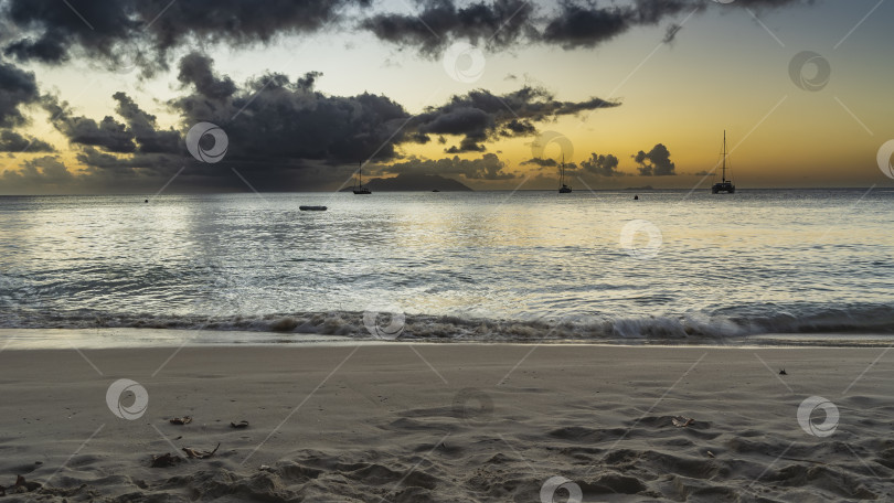 Скачать Вечерние сумерки на тропическом пляже. Живописные облака на подсвеченном оранжевом небе. фотосток Ozero