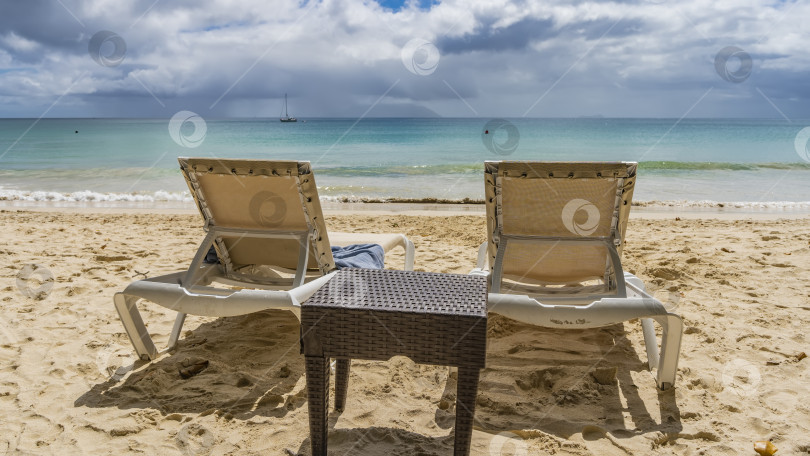 Скачать Два шезлонга и плетеный столик на тропическом пляже. фотосток Ozero