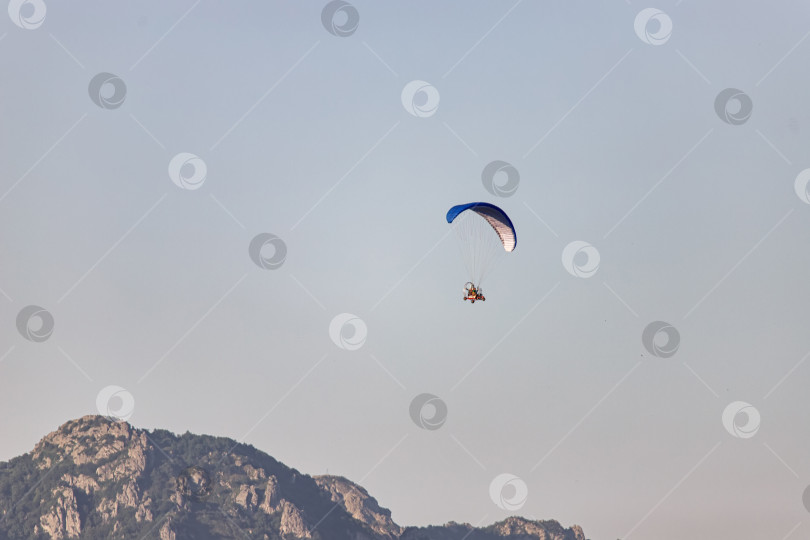 Скачать Туристы летают на мотоциклах-парапланеристах над горами фотосток Ozero
