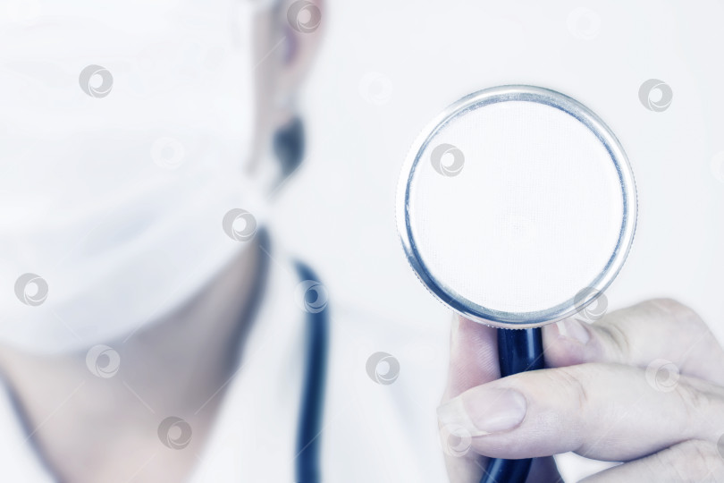 Скачать Стетоскоп для осмотра пациента на фоне врача в белой медицинской маске. Концепция здравоохранения фотосток Ozero