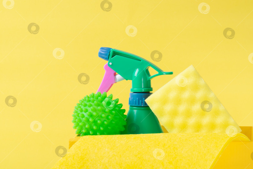 Скачать Набор для очистки на желтом. Зеленый баллончик с распылителем, шарик для стирки, губка и тряпка. фотосток Ozero
