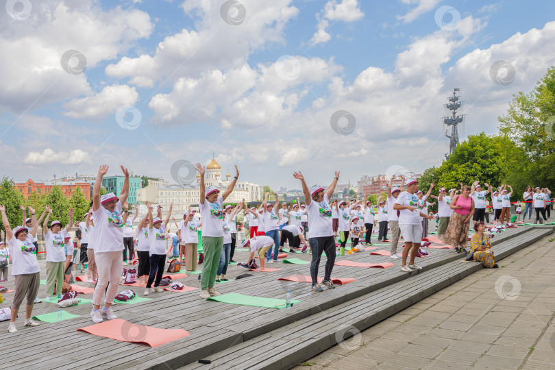 Скачать Московские пенсионеры делают гимнастику в парке Музеон на фоне храма Христа Спасителя. фотосток Ozero