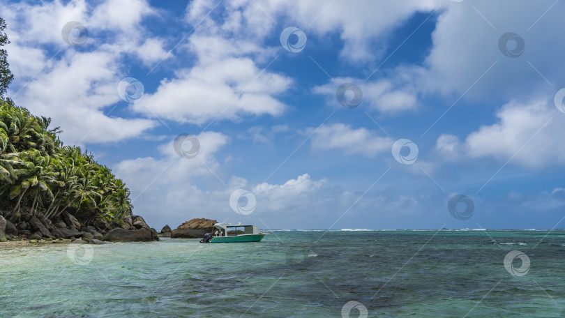 Скачать Лодка пришвартована в бирюзовом океане у тропического острова. фотосток Ozero