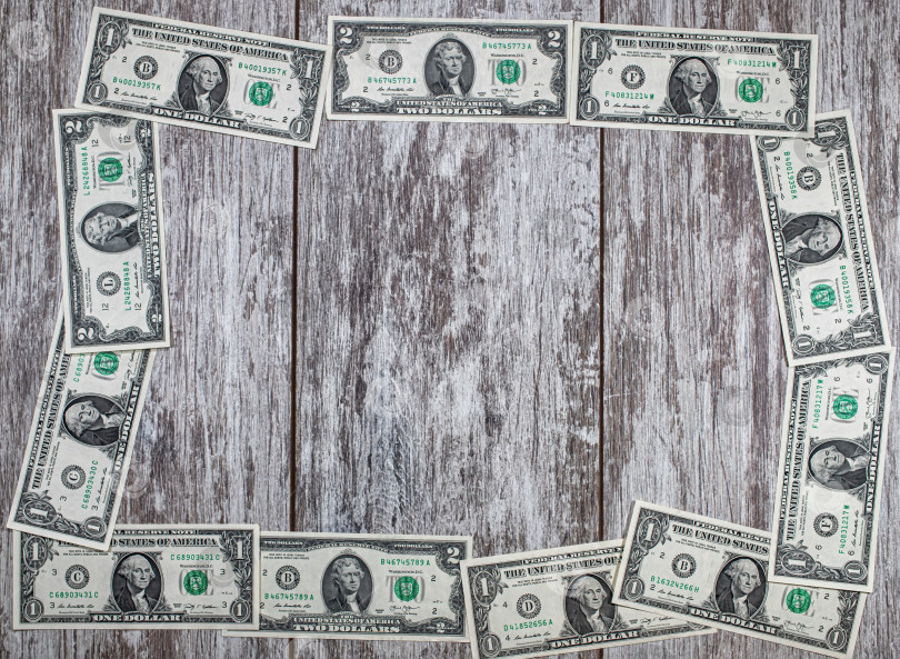 Скачать Рамка из долларовых купюр выложена на деревянном фоне фотосток Ozero