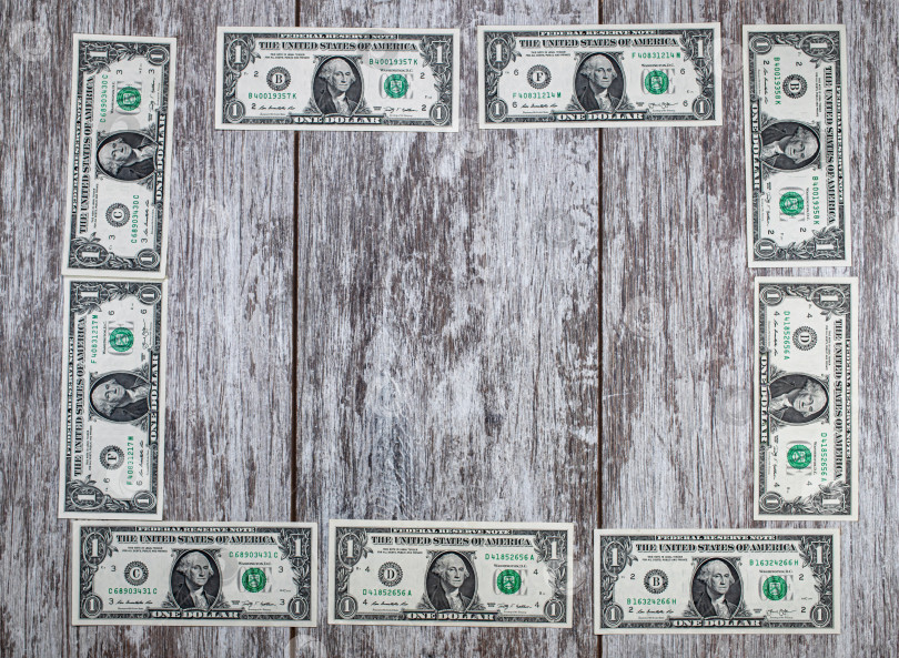 Скачать Рамка из долларовых купюр выложена на деревянном фоне фотосток Ozero