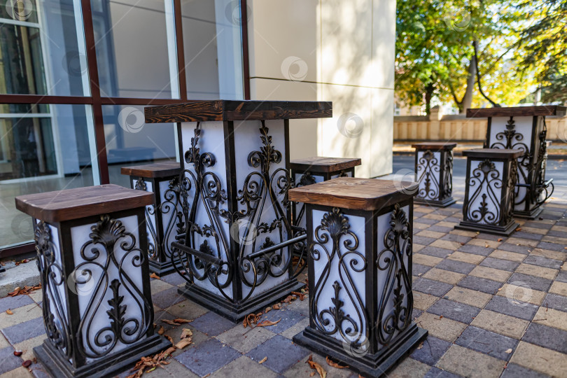 Скачать Элегантные столы и стулья с элементами из кованого железа во внутреннем дворике летнего кафе фотосток Ozero