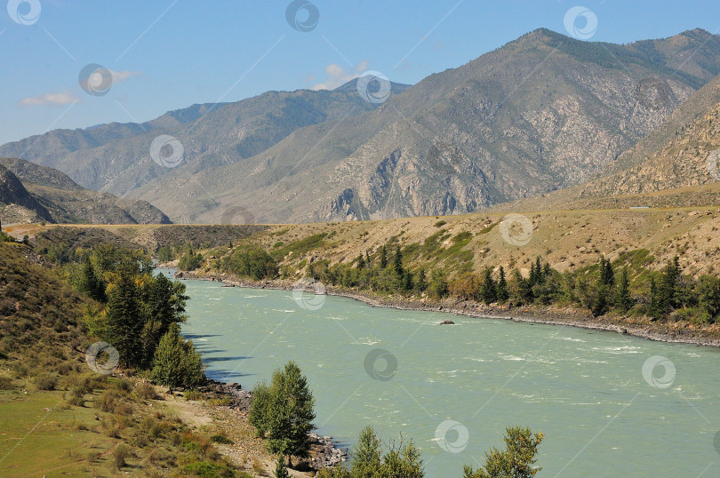 Скачать Вид с высокого берега бирюзовой реки, протекающей по живописной долине, залитой теплым летним солнцем. фотосток Ozero
