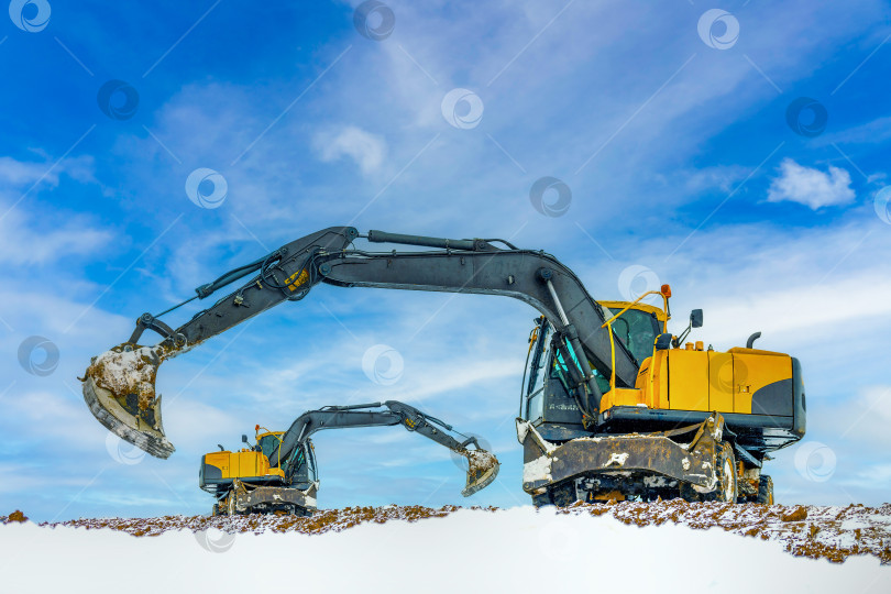Скачать Экскаватор работает на землеройных работах в песчаном карьере зимой. фотосток Ozero