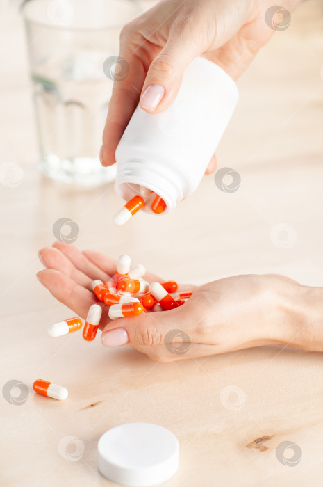 Скачать Женская рука высыпает таблетки на ладонь из пакетика фотосток Ozero