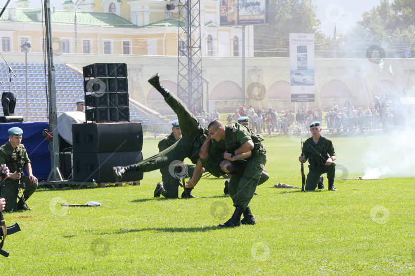 Скачать 2 августа во время празднования дня ВДВ на показательных выступлениях спецназа десантник производит эффектный бросок, отбирая при этом у противника нож. Сзади видны задымлённые трибуны, наблюдающие зрители и фрагмент православного Храма. фотосток Ozero