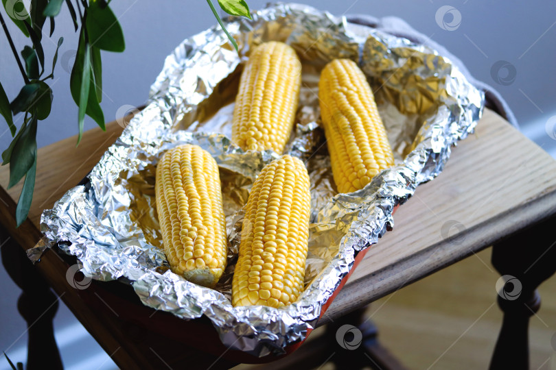 Скачать Сырую кукурузу в початках выложить в форму для запекания. Подготовьте кукурузу перед приготовлением. Сезон овощей. Свежие кукурузные початки, подготовленные для приготовления запеченной кукурузы. Здоровое питание. Концепция веганского питания фотосток Ozero