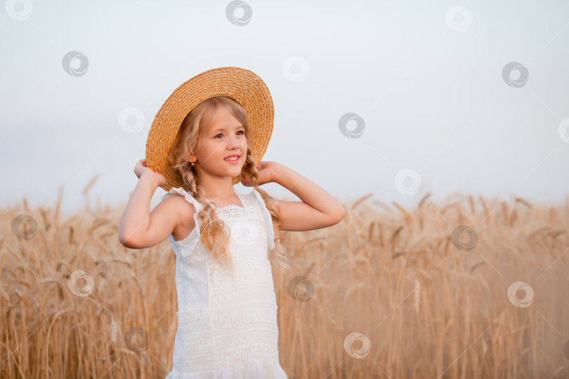 Скачать Маленькая белокурая девочка гуляет по летнему пшеничному полю фотосток Ozero