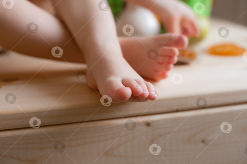 Скачать ножки ребенка на деревянном столе с фруктами крупным планом фотосток Ozero