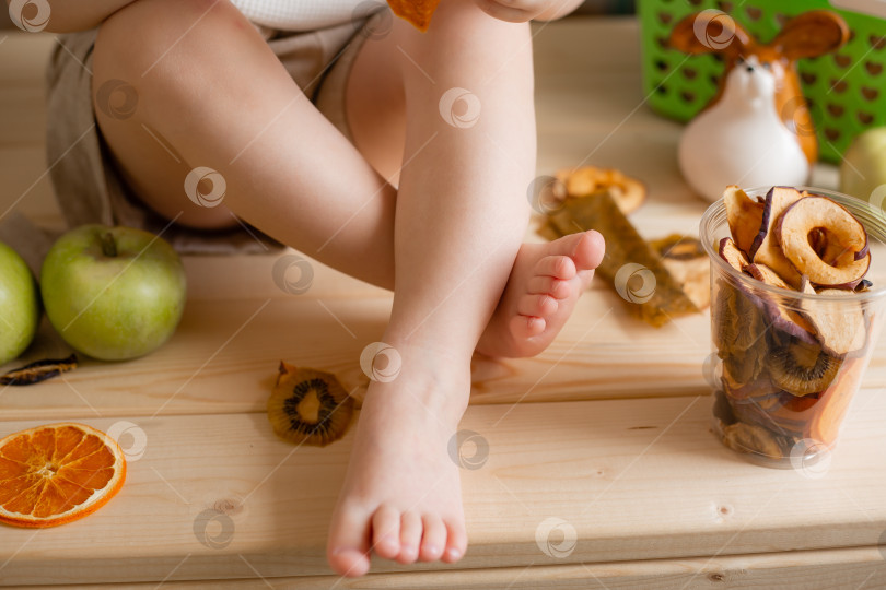 Скачать ножки ребенка на деревянном столе с фруктами крупным планом фотосток Ozero