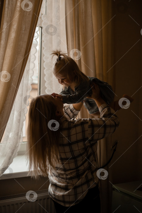 Скачать Мама обнимает малыша у окна дома. счастливое материнство фотосток Ozero