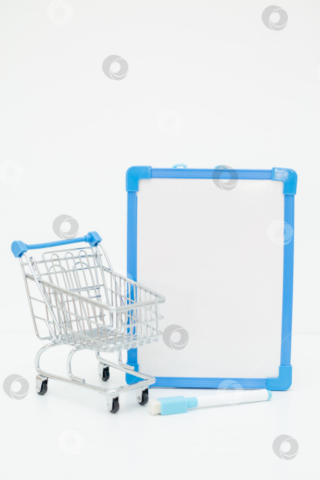 Скачать корзина для покупок рядом с белой доской объявлений в синей рамке. список покупок, текстовое пространство фотосток Ozero
