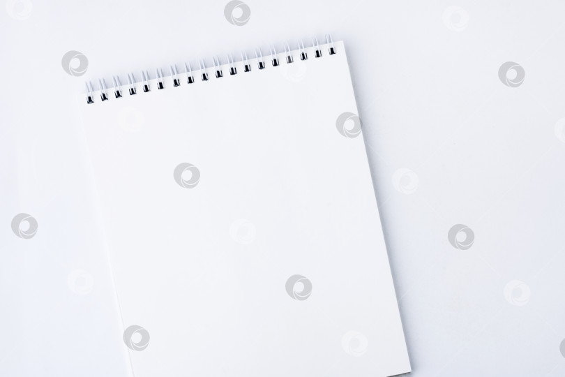 Скачать Белый открытый блокнот. Белый блокнот со страницами, скрепленными спиралью, на белом фоне. Пространство для копирования фотосток Ozero