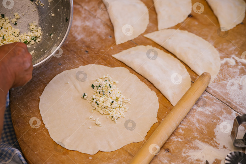 Скачать Женские руки в процессе приготовления кутабы или чебуреков, мясной фарш и лук в тесте.Творог и лук в тесте. Азербайджанская, татарская, кавказская, греческая кухня. фотосток Ozero