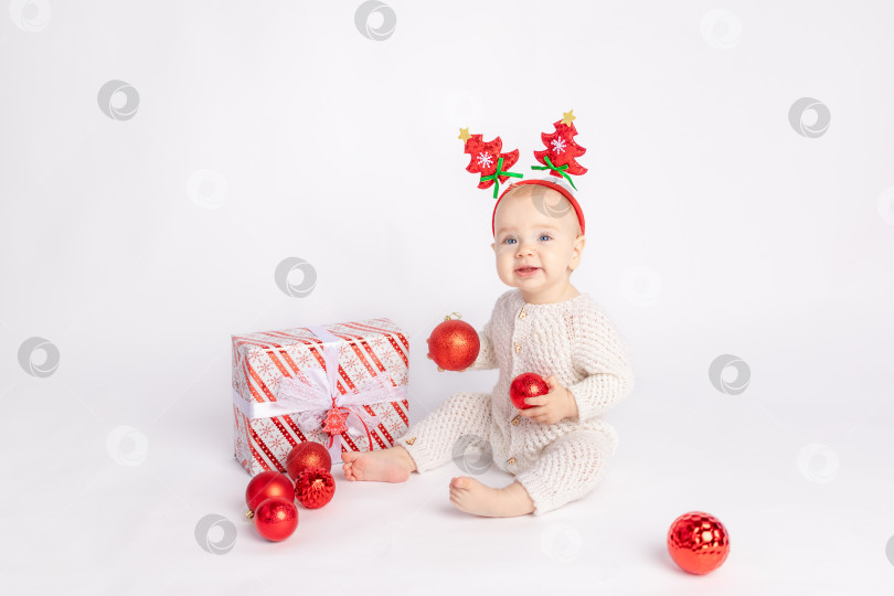 Скачать ребенок с подарком и рождественскими шарами на белом изолированном фоне, место для текста, концепция нового года и Рождества фотосток Ozero